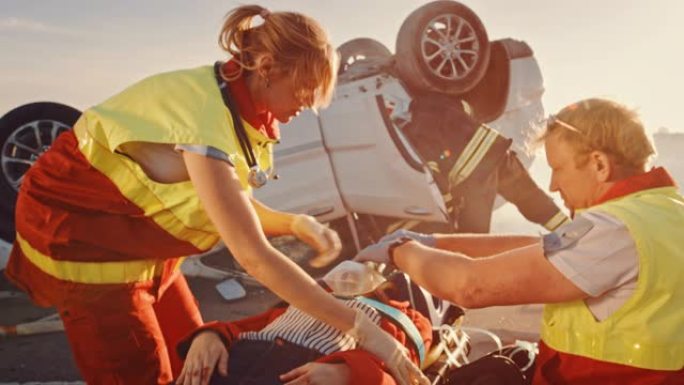 在车祸交通事故现场: 医护人员挽救了躺在担架上的一名女性受害者的生命。他们听心跳，戴上氧气面罩并进行