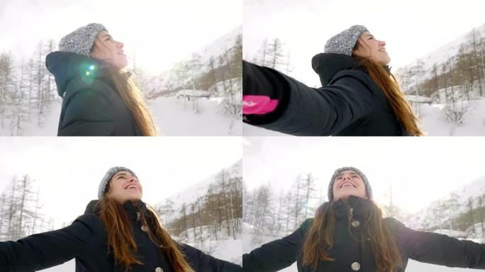 在冬天的日子里，一个美丽的女人在山上玩雪，呼吸着沉浸在大自然中的清洁空气。