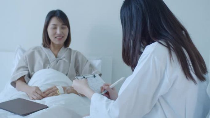 亚裔女医生填写病患政策与病患交谈