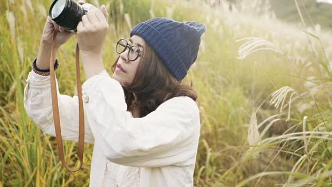 亚洲旅游女子用相机在山腰拍照