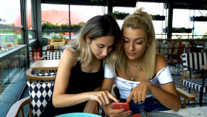4k两个年轻女人在咖啡馆或餐馆里交谈。