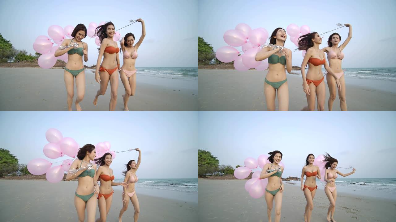 一群快乐的女孩朋友拿着快乐的气球在沙滩上奔跑。有派对庆祝概念的人。4k分辨率。慢动作镜头。