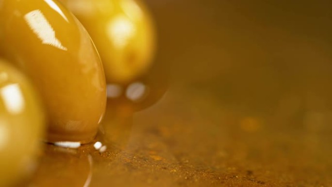 慢动作: 金色橄榄油溅到美味的国产腌制橄榄上。