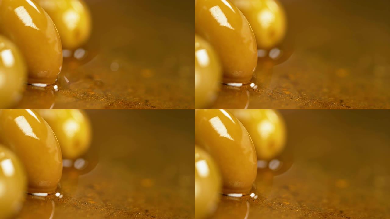 慢动作: 金色橄榄油溅到美味的国产腌制橄榄上。