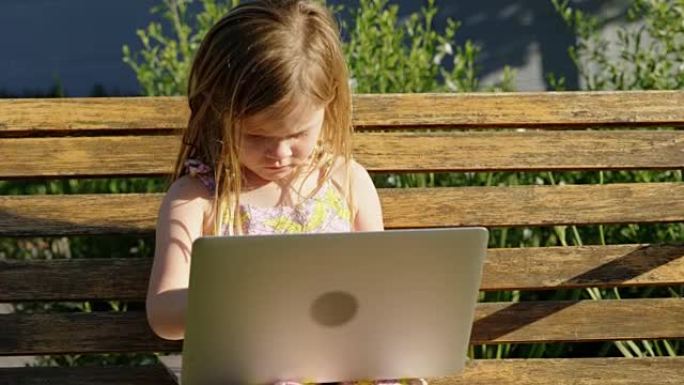 女孩在花园里使用笔记本电脑4k