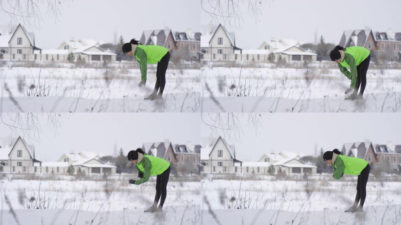 女人在冬天在户外做前弯运动
