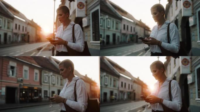 女士在黄昏时在城市使用智能手机的现代女商人