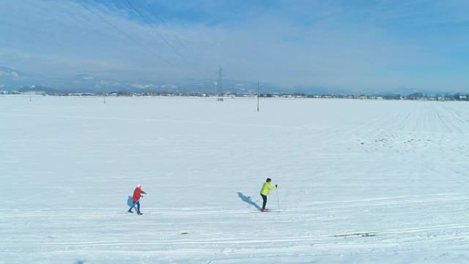 空中: 沿着两个女子越野滑雪者穿越广阔的平原飞行