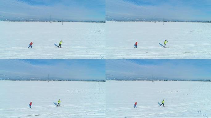 空中: 沿着两个女子越野滑雪者穿越广阔的平原飞行