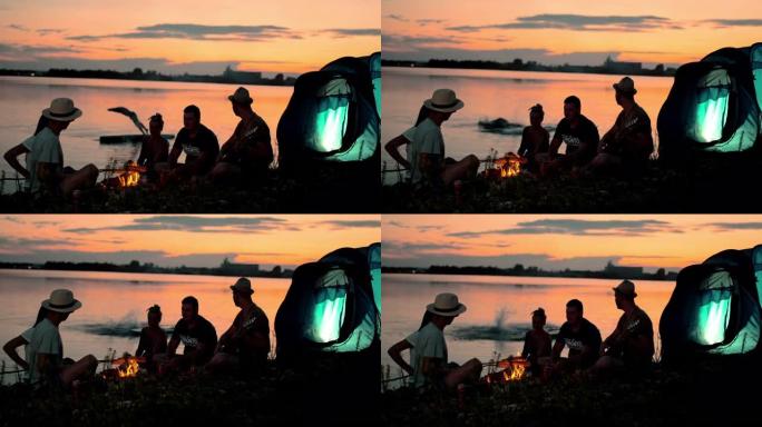 超级SLO MO一群年轻人在黄昏时在湖边露营
