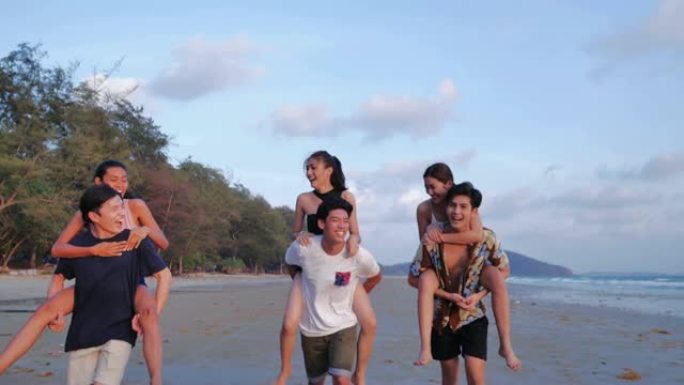 暑假期间，快乐的男朋友在热带海滩上piggy带他们的女朋友，一起欢笑。假期-iStock