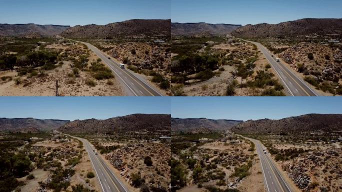 美丽的电影空中拍摄，汽车和露营车在美国阳光明媚的沙漠山路上行驶。公路旅行冒险。