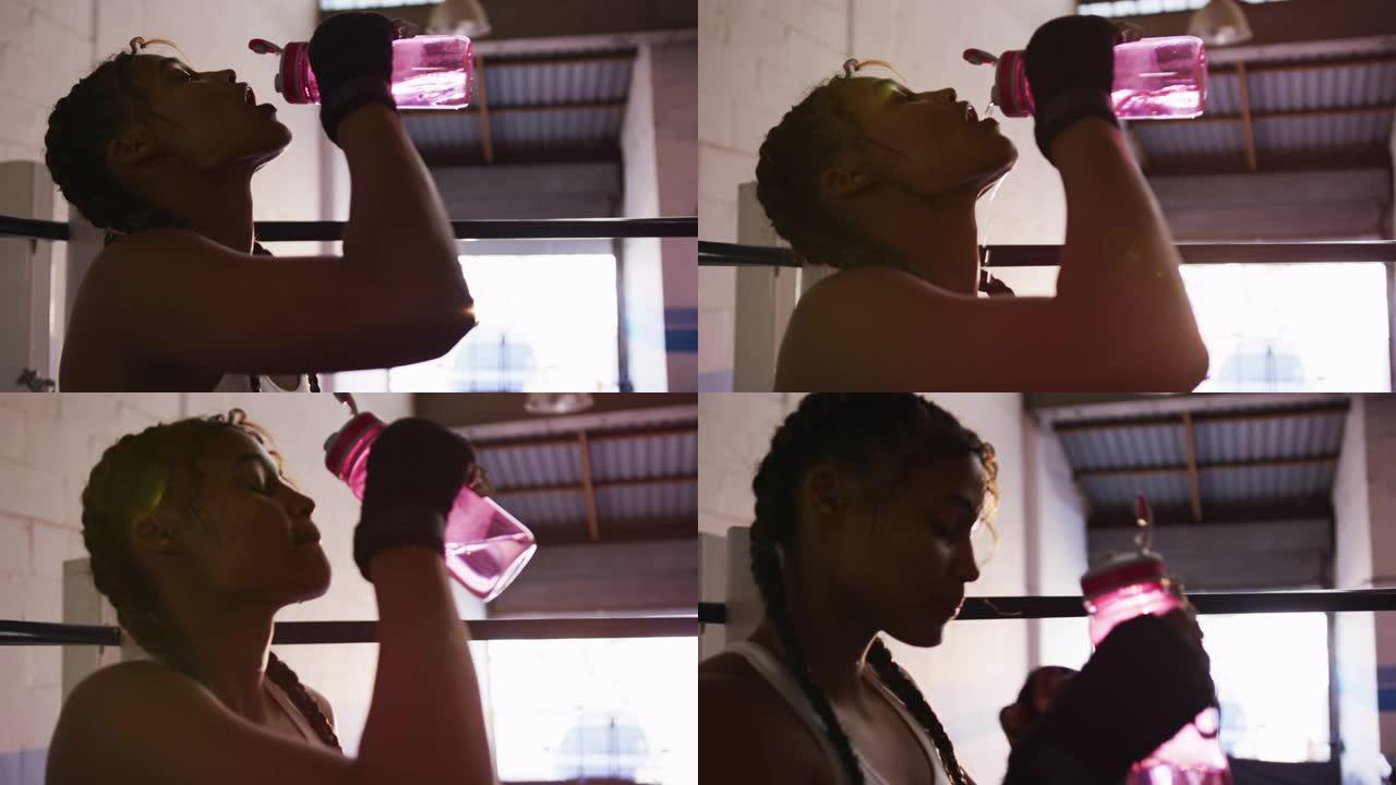 混血女子在拳击馆喝水