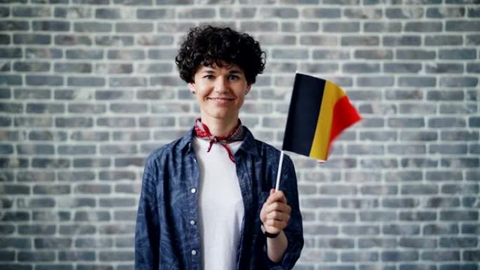 手持德国官方国旗微笑的美女慢动作肖像