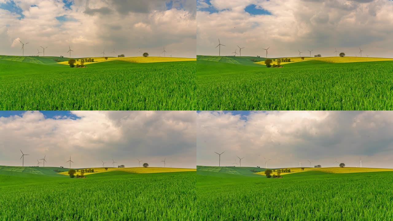 风力涡轮机在远处旋转的绿地上的T/L云景