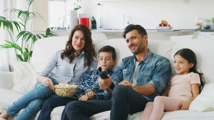幸福家庭的肖像在客厅的沙发上慢动作看电视。