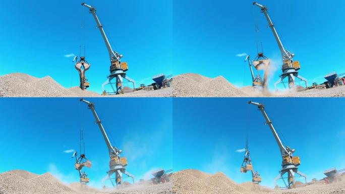 两台起重机在采石场工作，移动瓦砾。工业采矿概念。