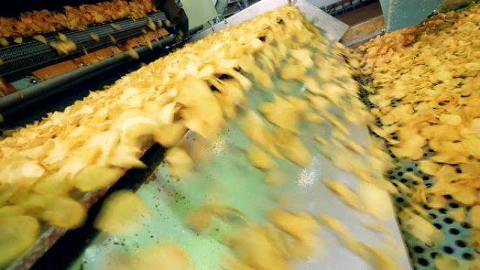 工厂设备在一条特殊的生产线上移动薯片，即食品生产设施。