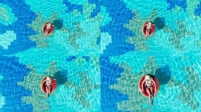 游泳池的俯视图，一位女士在游泳圈中。暑假概念。