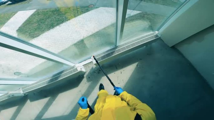 男性清洁剂用防腐剂喷洒窗户。