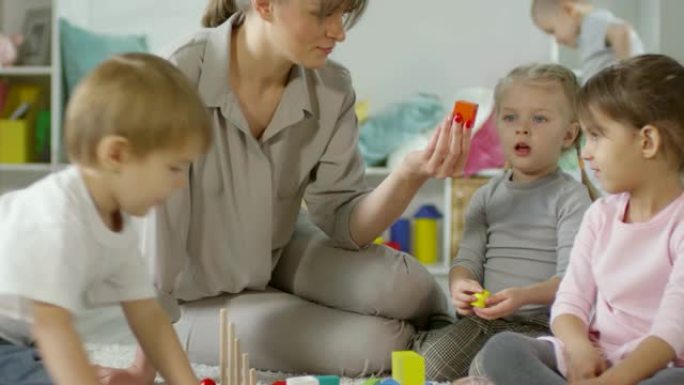 女教师和孩子在幼儿园玩益智玩具