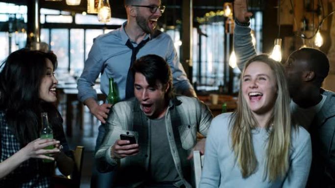快乐的三个大学朋友在酒吧里一起喝啤酒和欢呼的慢动作
