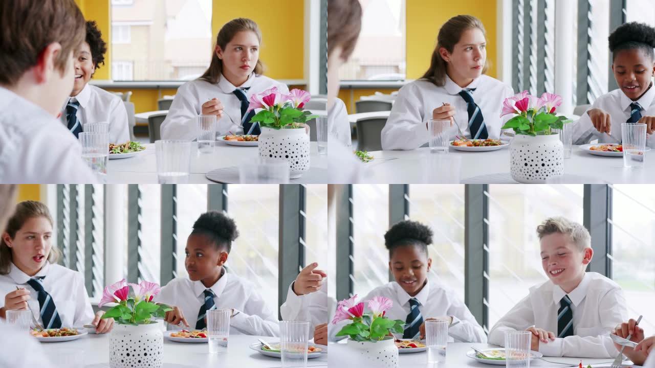 一群穿着制服的高中生围坐在桌子旁，在自助餐厅吃午餐
