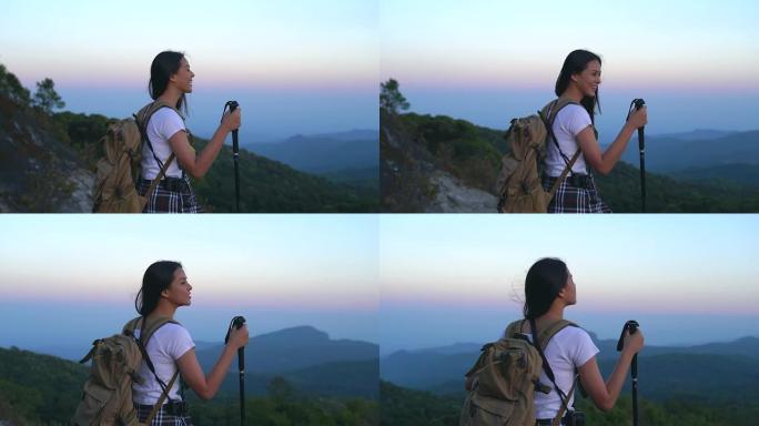 年轻的旅游女子在山顶徒步旅行，看着美丽的风景。