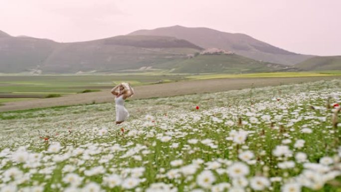 WS旺盛的年轻女子在意大利翁布里亚卡斯特鲁乔的田园诗般的野花草地上奔跑