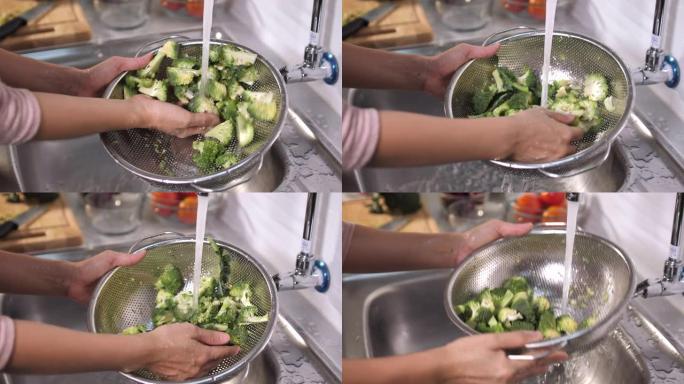 女人在厨房用漏勺洗西兰花蔬菜的特写镜头