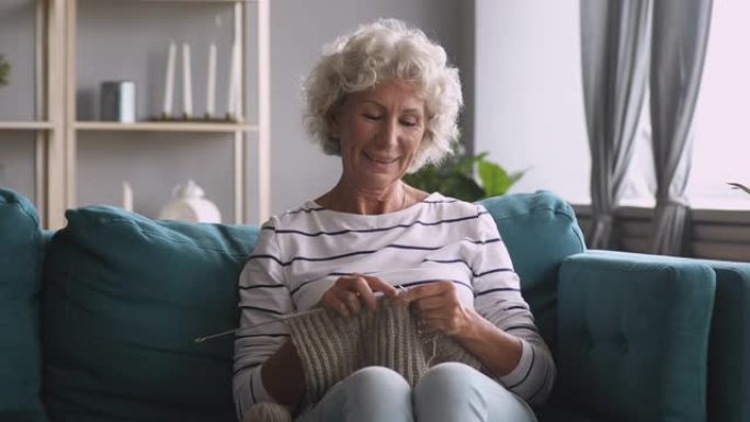 微笑的老奶奶编织围巾在家享受休闲爱好