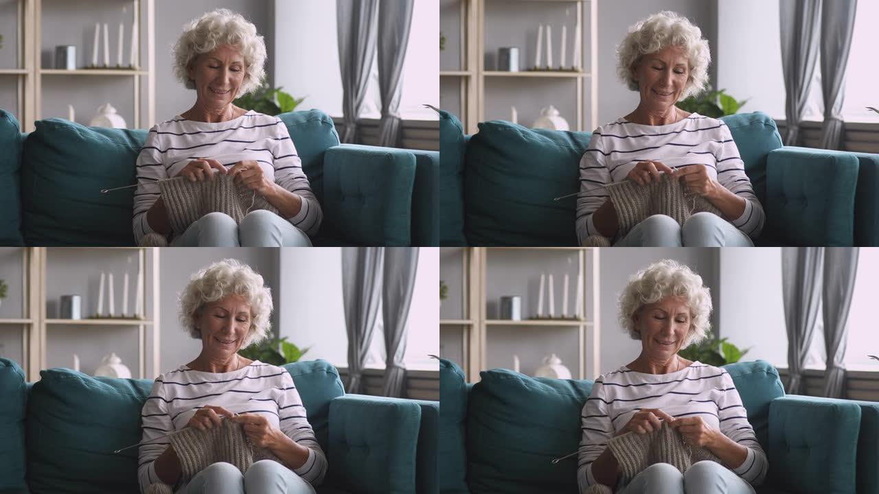 微笑的老奶奶编织围巾在家享受休闲爱好
