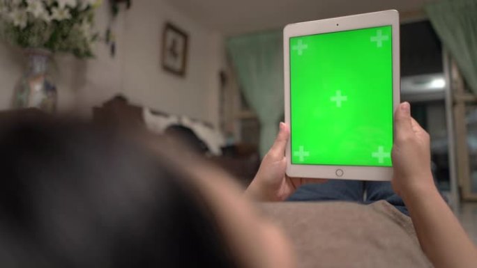 在家使用绿屏平板电脑放松女人