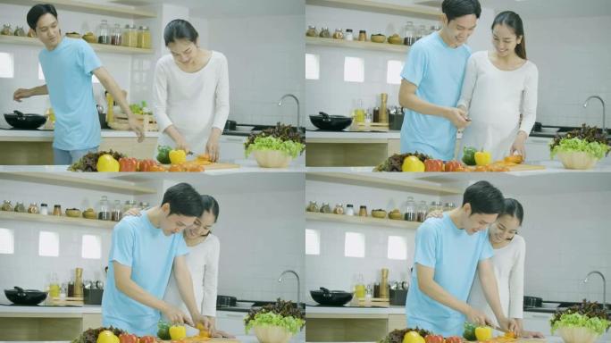 孕妇和她的丈夫在家里的厨房里一起准备健康的食物。亚洲夫妇一起做饭玩得很开心。有生活方式概念的人。