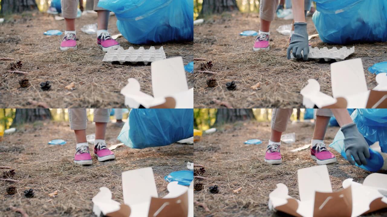 手套的特写镜头在森林里捡垃圾做慈善工作帮助大自然