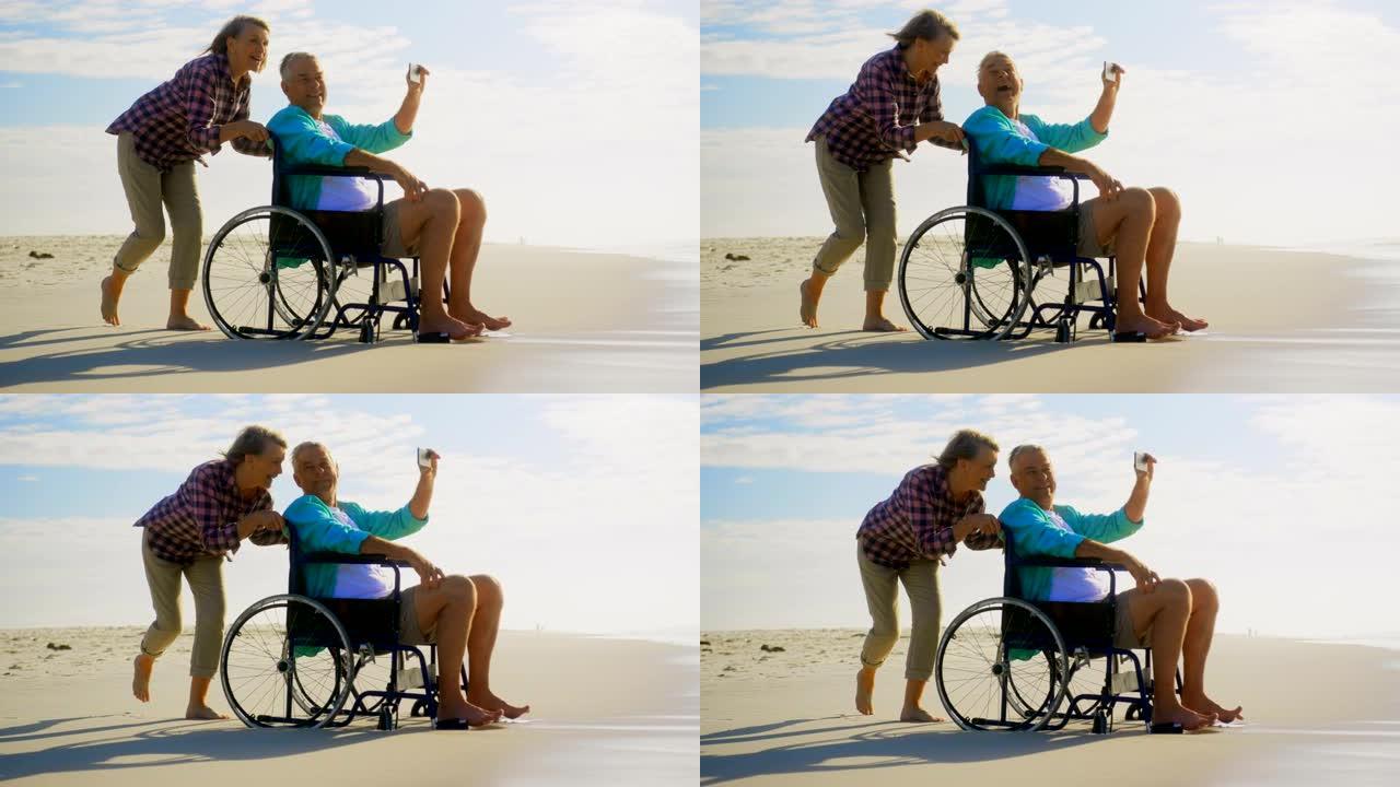 活跃的高级高加索夫妇在海滩上用手机自拍的侧视图4k