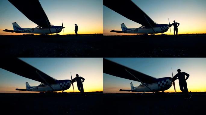 站在日落背景下飞机附近的人。小航空概念。