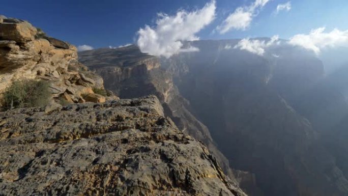 阿曼杰贝沙姆斯山。走在岩石的边缘。摄像机向前移动。云雾笼罩着这座山。4K