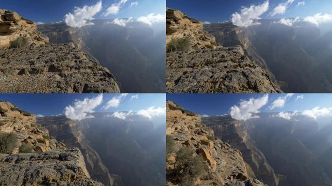 阿曼杰贝沙姆斯山。走在岩石的边缘。摄像机向前移动。云雾笼罩着这座山。4K