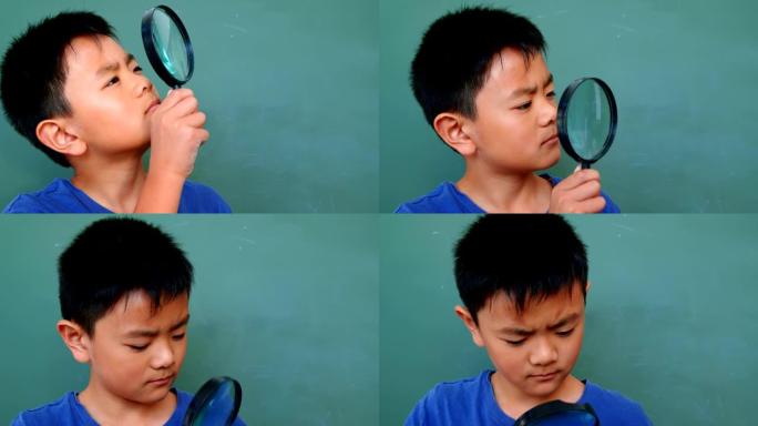 4k学校教室里亚洲男生透过放大镜看的前视图