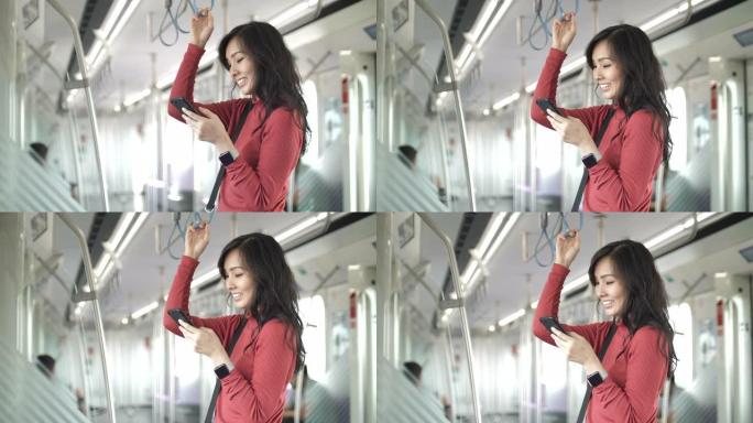 年轻的亚洲女性在地铁的公共交通中使用智能手机