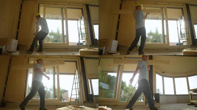 低角度: 承包商拿起一块木板，将其穿过CLT房屋。