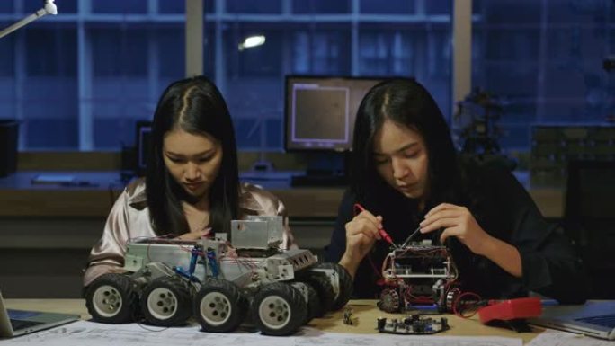 年轻的电子开发工程师团队在实验室晚上建造，测试，固定机器人原型。有技术或创新概念的人。