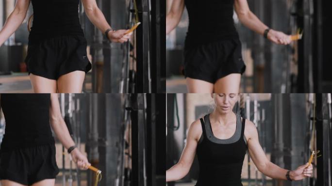 特写年轻美丽健康的女人在健身房用跳绳锻炼，引领健康积极的生活方式慢动作。