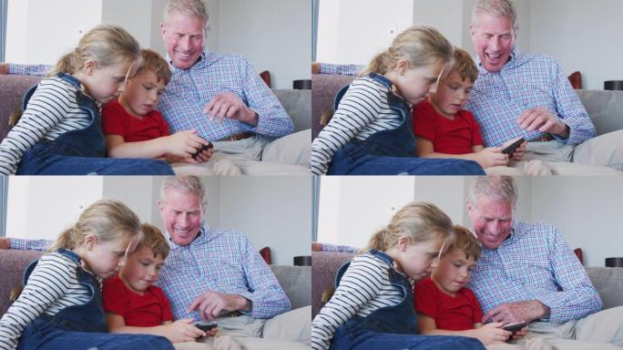 爷爷在家用手机和孙子玩电子游戏