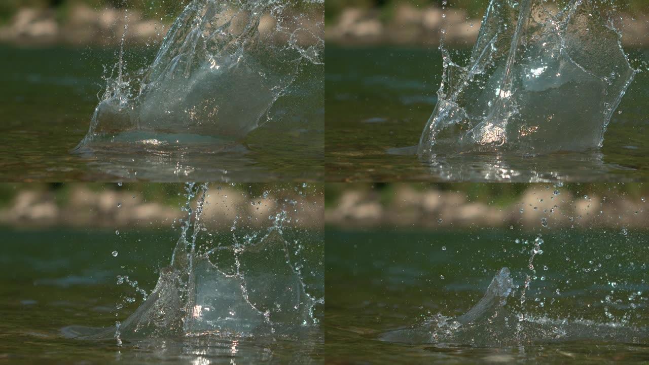 宏观: 河流中的岩石坠落后，玻璃状的水在阳光下闪烁