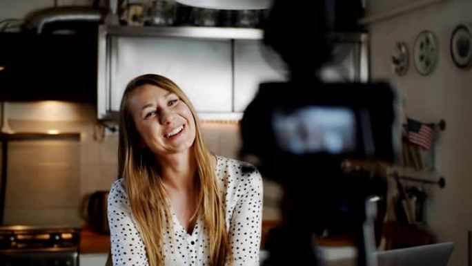 快乐年轻美丽的食物博主女人用专业相机在厨房慢动作拍摄新的vlog视频。