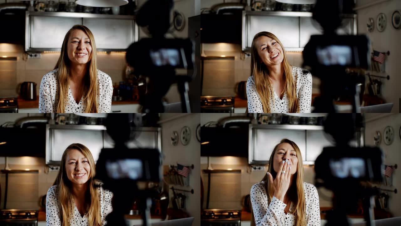 快乐年轻美丽的食物博主女人用专业相机在厨房慢动作拍摄新的vlog视频。