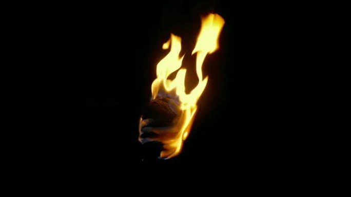 燃烧的火炬被举起，然后关闭特写镜头