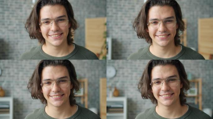 戴眼镜的男学生在屋子里微笑的特写肖像
